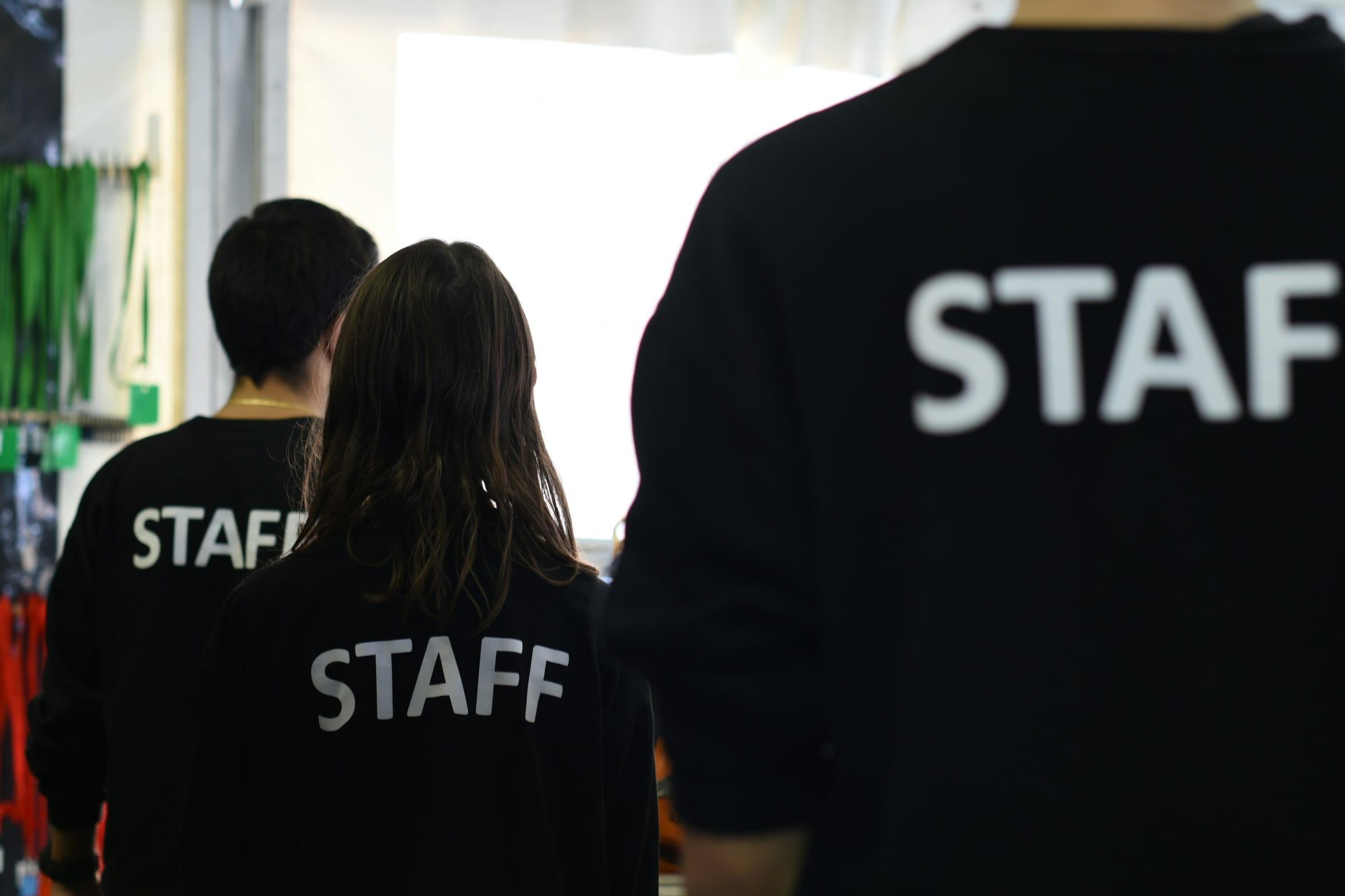 Casual staff in branded jackets walking through a venue before a shift.