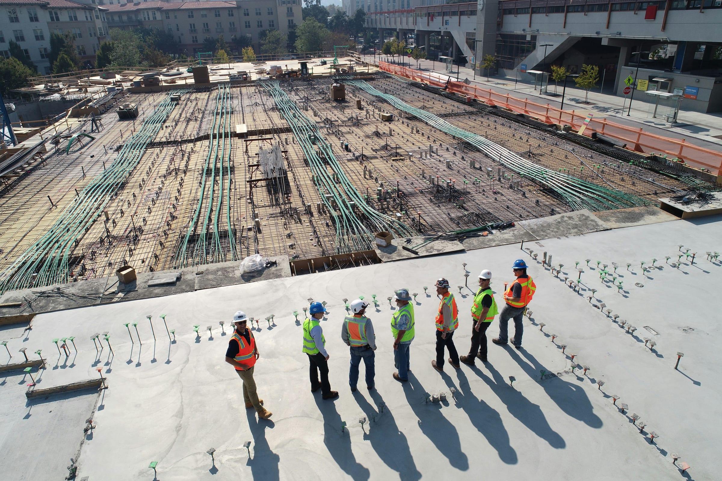 Construction workers in high-visibility gear on an active building site.